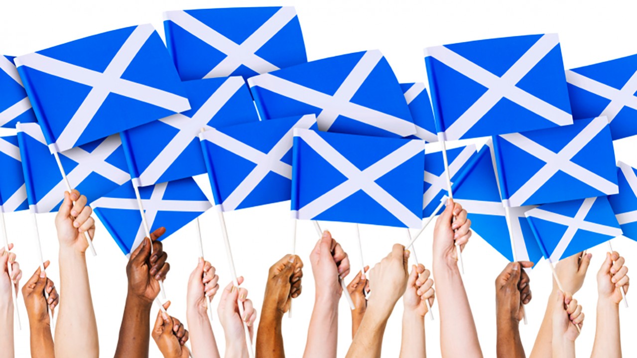 hands holding Scottish flags
