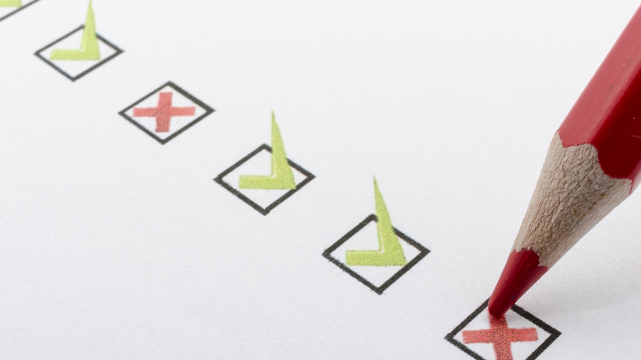 Close up of red pencil marking checkbox with a cross