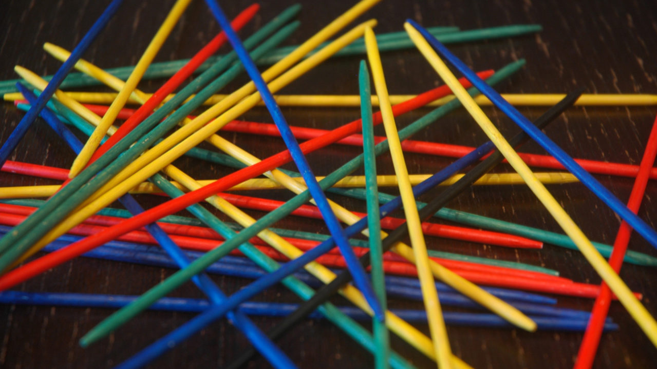Pick up sticks game on black background