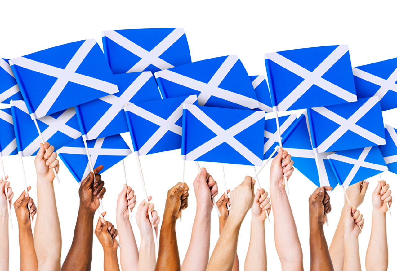 hands holding Scottish flags